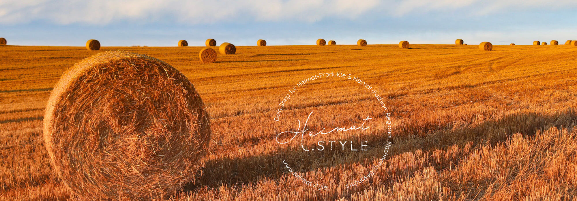 Heimat.Style Logo auf Feld mit Strohballen