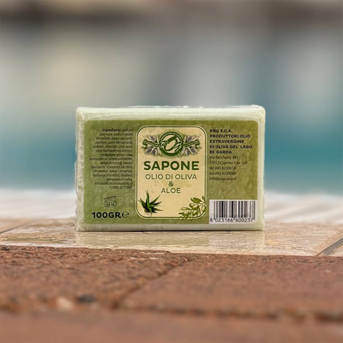 Seifenstück aus Olivenöl und Aloe steht auf dem Rand eines Pools