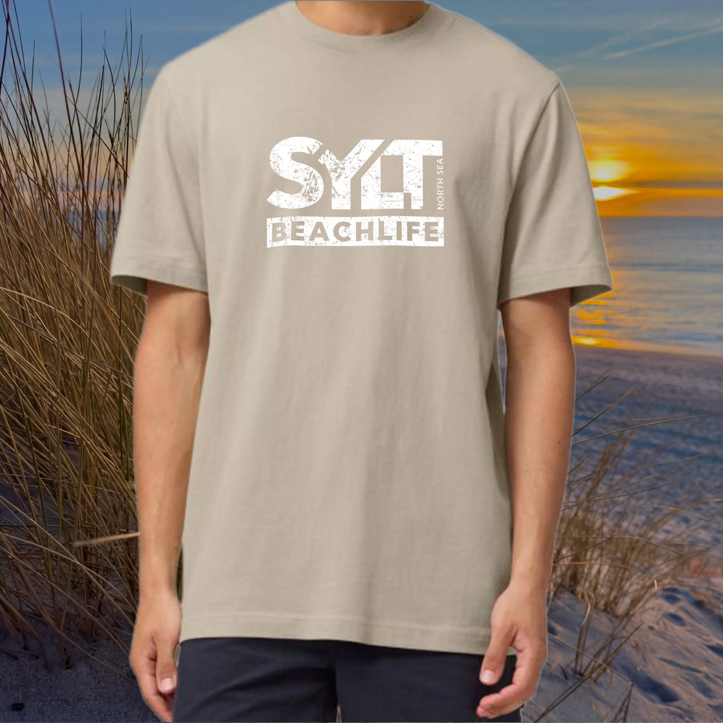 Mann trägt sandfarbenes Sylt Beachlife T-Shirt aus nachhaltiger Bio-Baumwolle bei Sonnenuntergang am Strand