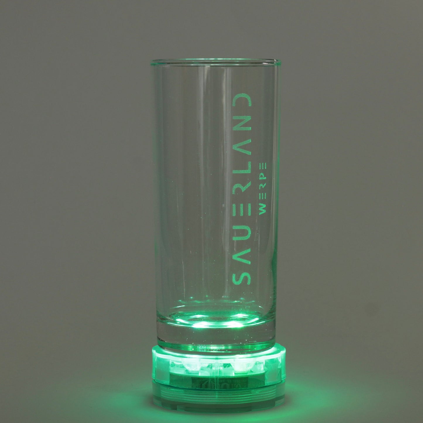 Ein Sauerland Trinkglas steht auf einer grünen, runden Lampe. Hierdurch ist die Gravur mit dem modernen Sauerland Logo und darunter, etwas kleiner, dem Dorfnamen Werpe zu sehen.