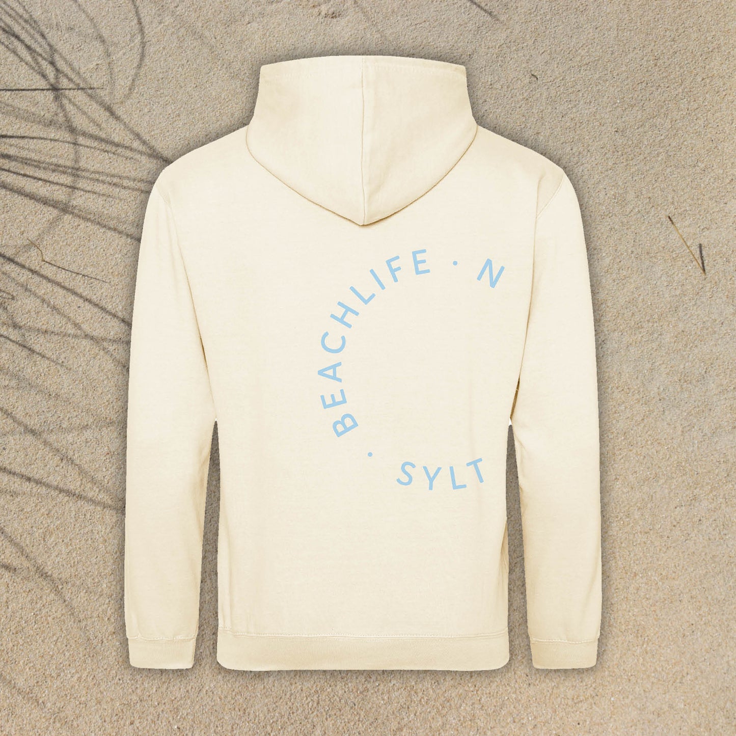 Hellbeige Hoodie ist auf der Rückseite in rund mit den Begriffen Beachlife Sylt bedruckt. Der Aufdruck ist hellblau. Der Kapuzen-Pullover hat im Hintergrund ein Sandmotiv mit Dünengras im linken Anschnitt.