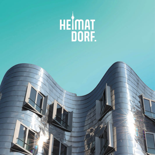 Vor türkisem Hintergrund sticht ein Stück des silbernen Gehry Hauses hervor.