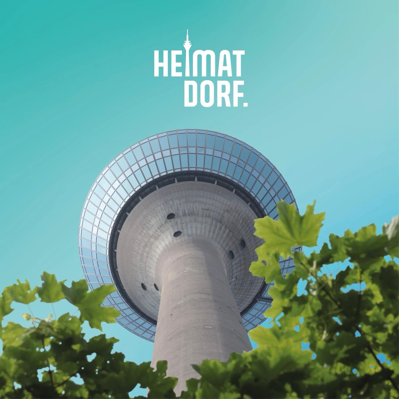 Vor türkisem Hintergrund ist der Rheinturm zu sehen. Im Hintergrund steht HEIMATDORF