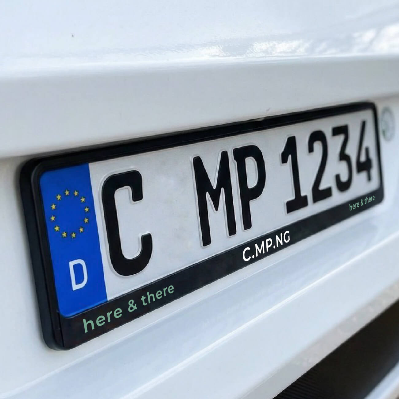 Nahaufnahme des Kennzeichenhalters eines Wohnmobils, der primäre Fokus liegt auf dem C.MP.NG Kennzeichenhalter original mit dem Schriftzug C.MP.NG here & there in farblicher abhebung.