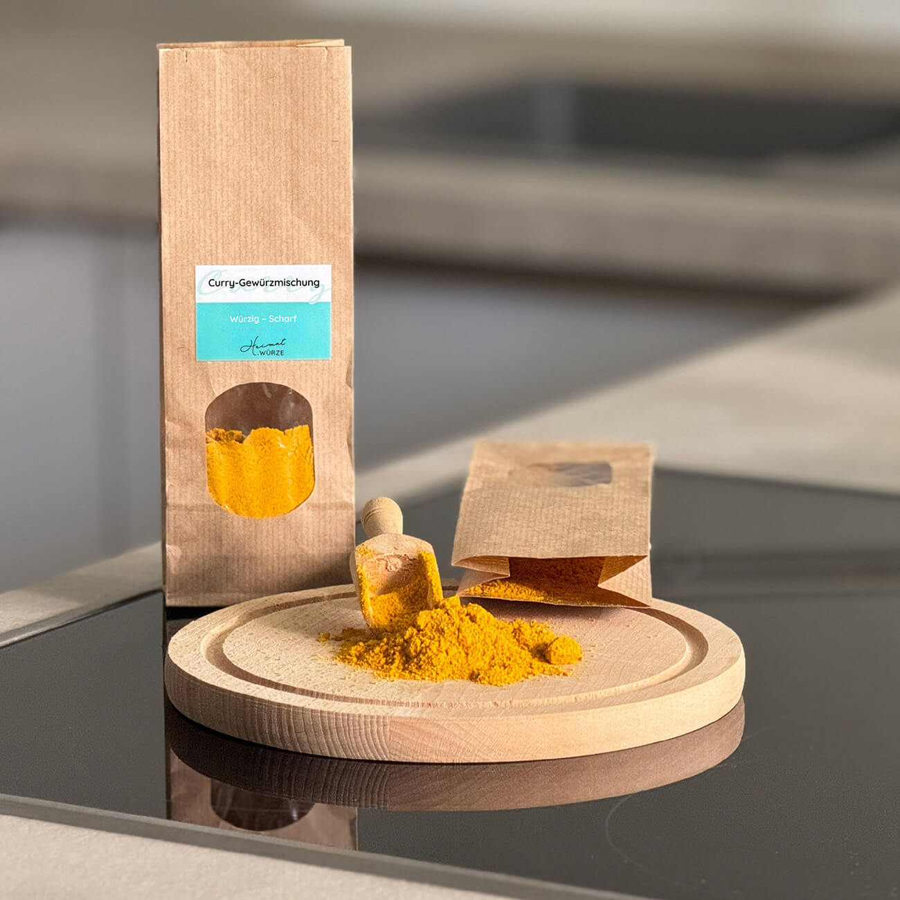 Tütchen mit Curry-Gewürzmischung steht in einer Küche. Davor ist auf einem Holzbrett etwas Curry-Pulver ausgeschüttet.