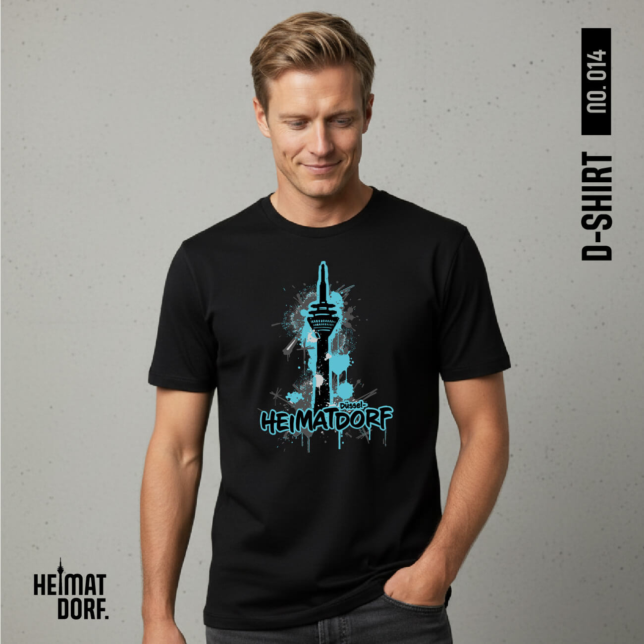 Ein blonder Mann trägt ein schwarzes Relaxed-Fit T-Shirt mit einem Graffiti-Aufdruck des Rheinturms und dem Schriftzug Heimatdorf Düsseldorf mit türkis-blauer Akzentfarbe.