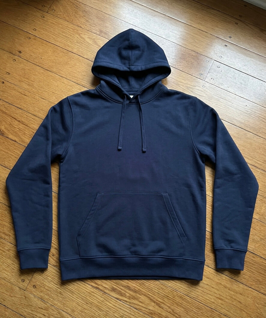 Ein Hoodie liegt ausgebreitet auf einem Holz-Fußboden