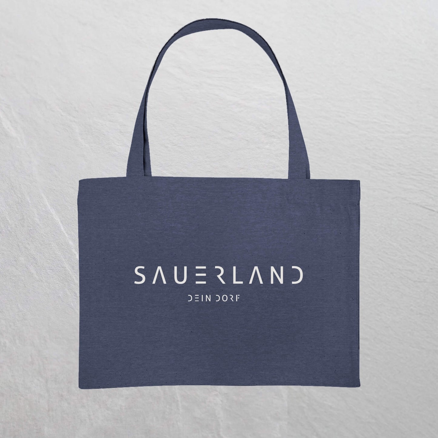Dunkelblaue  Baumwolltasche mit weißem Sauerland Logo bedruckt. Der moderne Schriftzug wird darunter mit dem Dorfnamen ergänzt. 