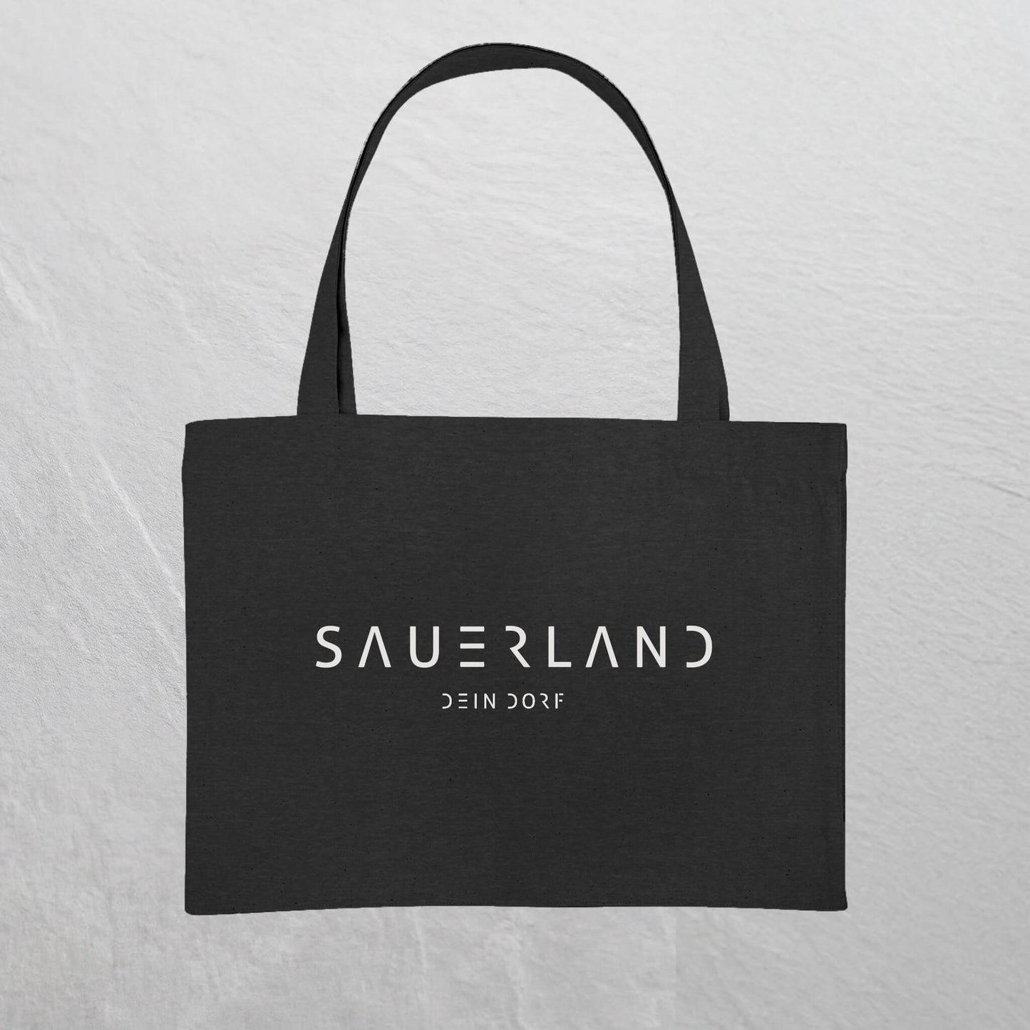Schwarze Baumwolltasche mit weißem Sauerland Logo bedruckt. Der moderne Schriftzug wird darunter mit dem Dorfnamen ergänzt. 