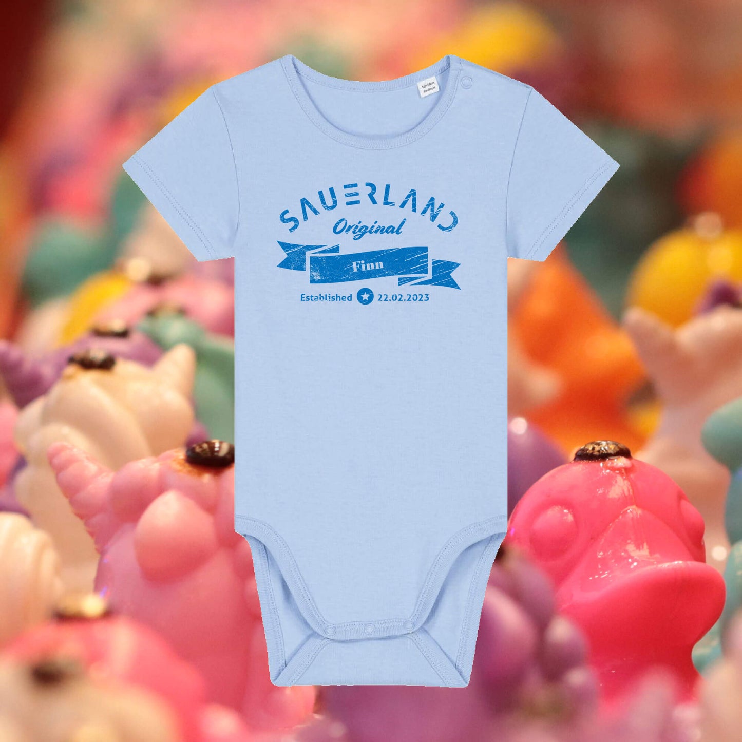 Sauerland Baby-Body in hellblau mit dunkelblauem Aufdruck Sauerland Original. Der Baby-Body kann mit dem Namen und Geburtsdatum des Kindes individualisiert werden.