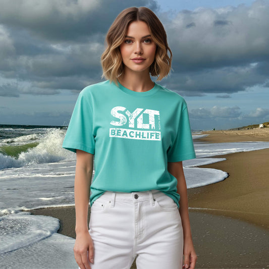 Frau trägt mint-grünes Sylt Beachlife T-Shirt aus Bio-Baumwolle am Nordseestrand mit Wellen im Hintergrund