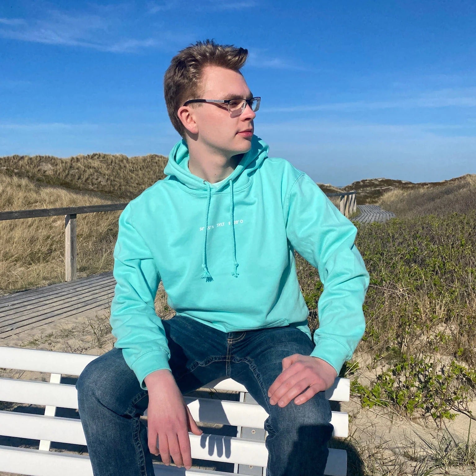 Sylt Hoodie in frischem Aqua-Ton mit weißem Schriftzug Sylt und Koordinaten auf der Brust