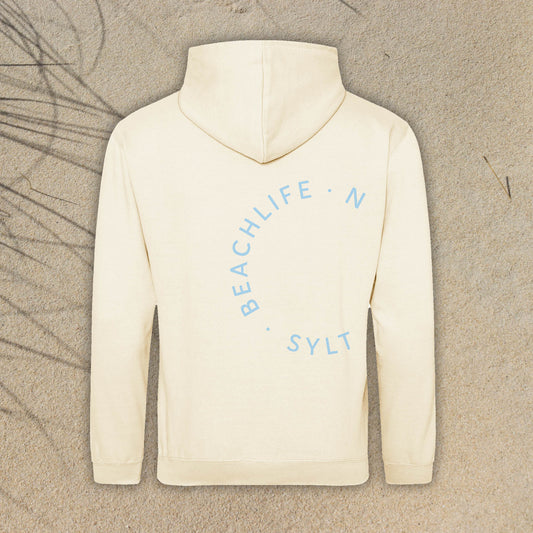Hellbeige Hoodie ist auf der Rückseite in rund mit den Begriffen Beachlife Sylt bedruckt. Der Aufdruck ist hellblau. Der Kapuzen-Pullover hat im Hintergrund ein Sandmotiv mit Dünengras im linken Anschnitt.